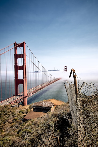 Verticale opname van de Golden Gate Bridge tegen een mistige blauwe lucht in San Francisco, Californië, VS