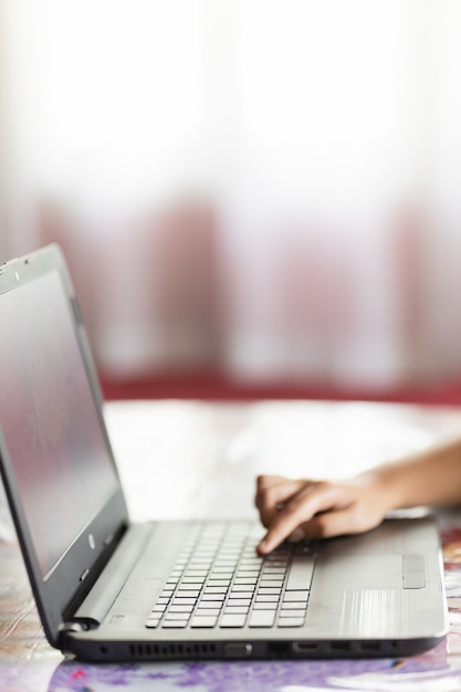 Verticale opname van de hand van een persoon die op een laptop typt