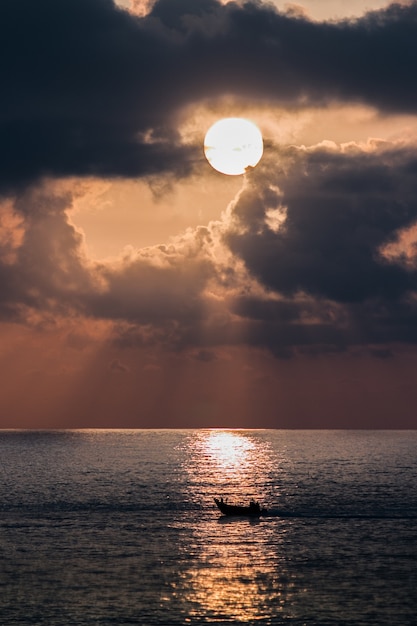 Verticale opname van een boot in een zee bij zonsondergang