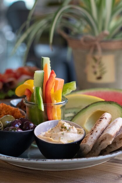 Verticale opname van een bord met traditioneel Ethiopisch eten, fruit en groenten op een houten tafel