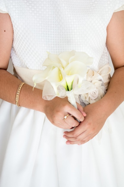 Verticale opname van een bruid met een prachtig bruidsboeket met witte bloemen