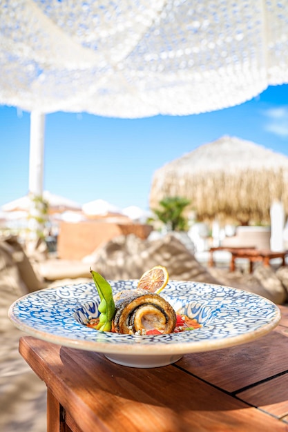 Verticale opname van een gastronomische visschotel in een restaurant aan het strand