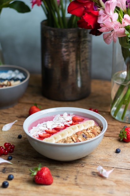 Verticale opname van een gezonde smoothiekom met fruit en muesli