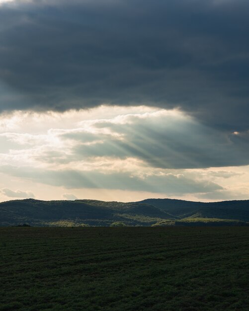 Verticale opname van een groen veld op het platteland onder de bewolkte avondrood