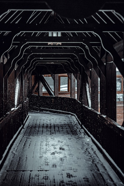Gratis foto verticale opname van een houten weg die leidt naar de trein bedekt met sneeuw