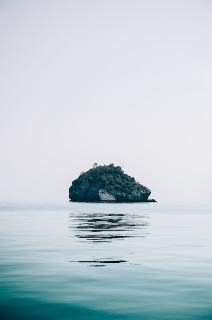 Verticale opname van een klein rotsachtig eiland in het midden van de oceaan, gevangen in Thailand