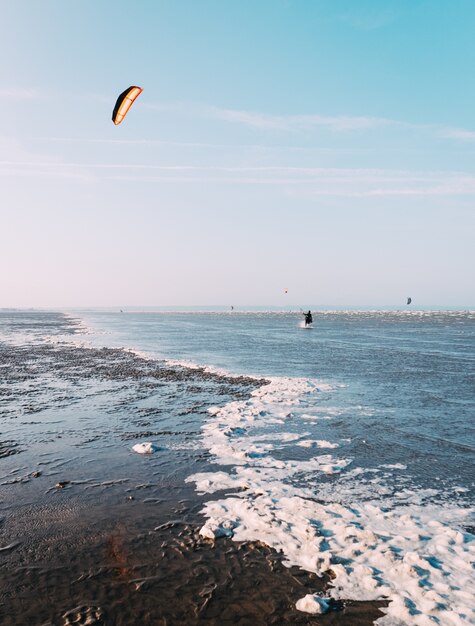 Verticale opname van een prachtig uitzicht op een zee met een blauwe lucht op de achtergrond