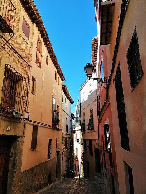 Verticale opname van een smal straatje met kleurrijke korte gebouwen in Toledo, Spanje