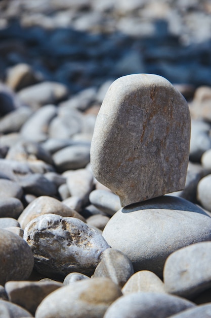 Verticale opname van een steen die overdag op anderen balanceert