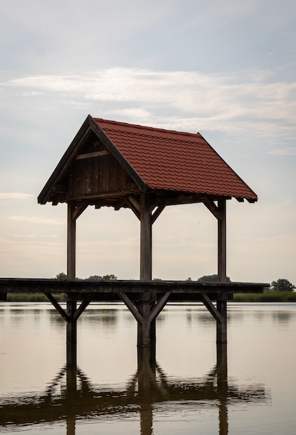 Gratis foto verticale opname van een tuinhuisje in een meer met weerspiegeling in het water