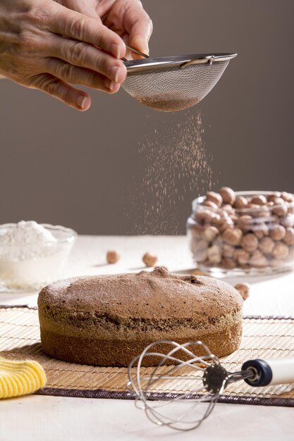 Verticale opname van een versgebakken chocolade-hazelnootcake bedekt met cacaopoeder