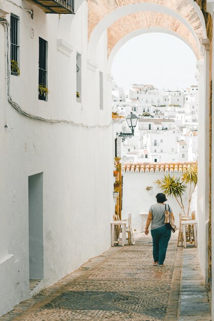 Verticale opname van een vrouw die door de smalle straatjes van Cadiz . loopt