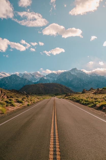 Verticale opname van een weg met de prachtige bergen onder de blauwe lucht, vastgelegd in Californië