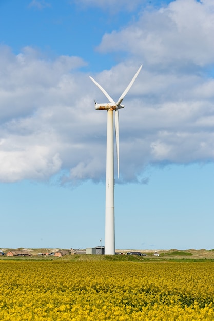Verticale opname van een windmolen in een veld onder een bewolkte hemel