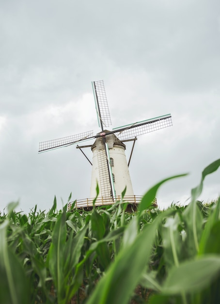 Verticale opname van een windmolen met een bewolkte grijze lucht