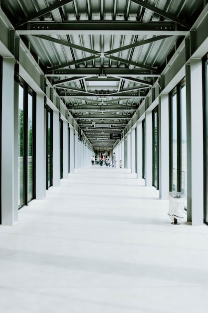 Gratis foto verticale opname van een witte gang met glazen deuren en een metalen plafond in een modern gebouw