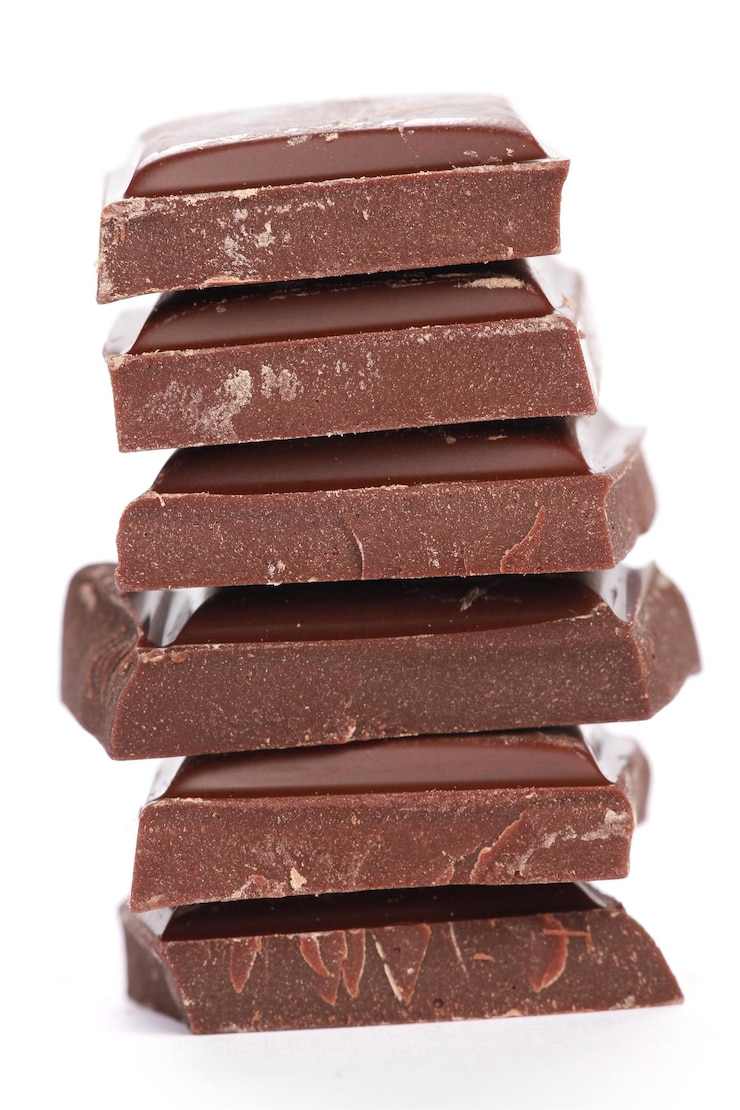 Gratis Foto verticale opname van gestapelde chocolaatjes op een witte achtergrond