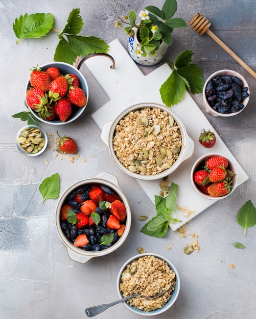 Verticale overhead schot van kommen gevuld met haver, aardbeien en blauw fruit