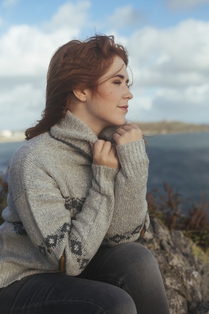 Verticale shot van een glimlachende vrouw met de zee