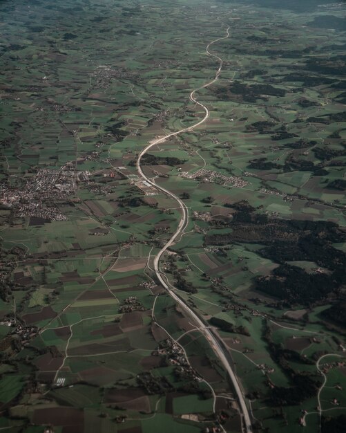 Verticale vogelvlucht van een eindeloze weg en groene velden