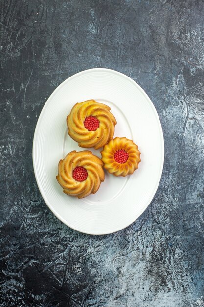 Verticale weergave van heerlijke koekjes op een witte plaat op een donkere ondergrond