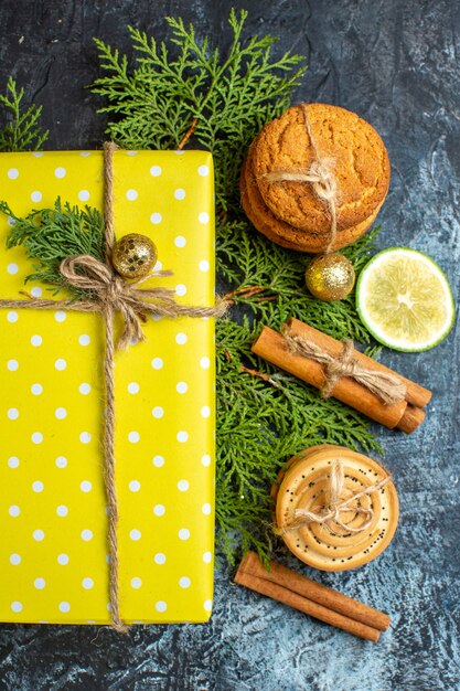 Verticale weergave van kerstachtergrond met mooie gele geschenkdozen en gestapelde koekjescitroen op donkere tafel