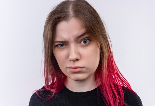 Verward jonge mooie vrouw, gekleed in zwarte t-shirt op geïsoleerde witte muur