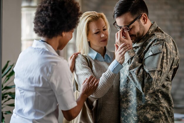 Verwarde veteraan huilt terwijl hij met zijn vrouw bij medische begeleiding in de kliniek is