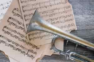 Gratis foto verweerde trompet op bladmuziek