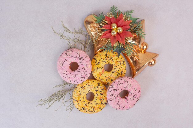 Vier kleurrijke zoete donuts op witte tafel.