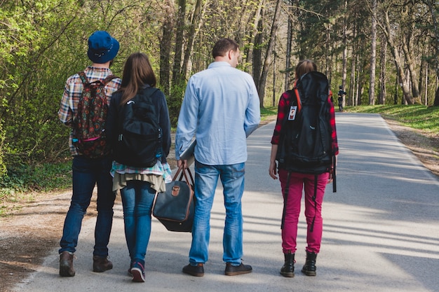 Vier toeristische vrienden die op het pad wandelen