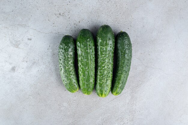 Vier verse komkommers geïsoleerd op een grijze achtergrond. Hoge kwaliteit foto