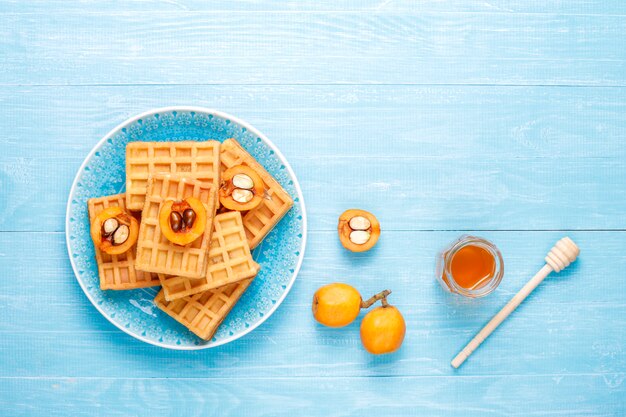 Vierkante belgische wafels met loquat fruit en honing