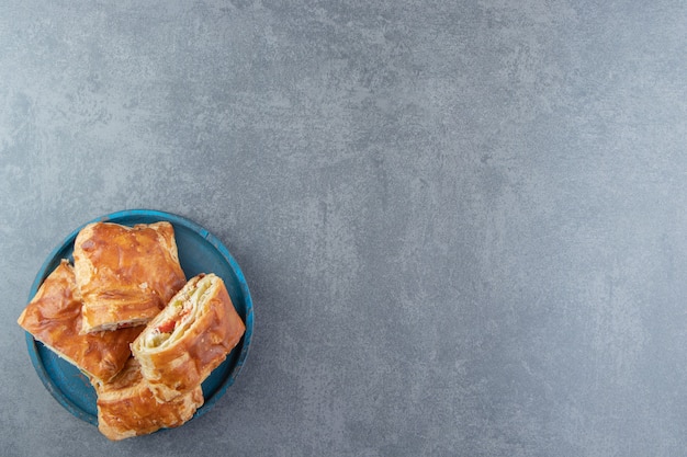 Vierkante gevulde gebakjes op blauw bord.