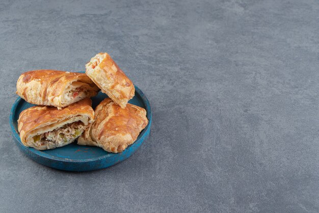 Vierkante gevulde gebakjes op blauw bord.