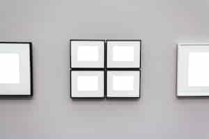 Gratis foto vierkante witte lege frames bevestigd aan een grijze muur
