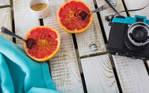 Vintage camera en servet met gehalveerde grapefruit op houten achtergrond