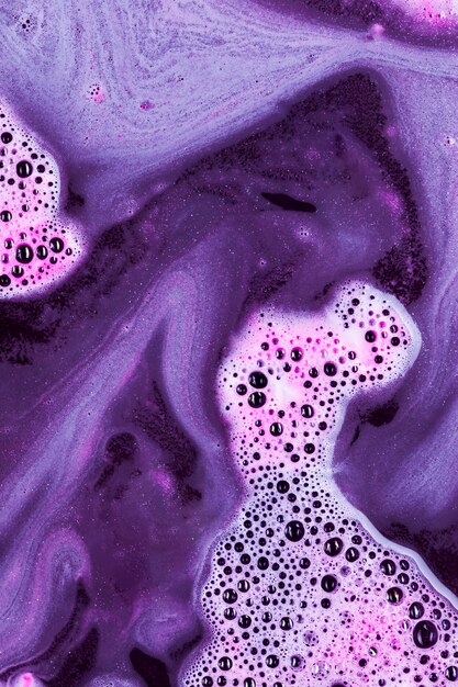 Violette vloeistof met lichtroze schuim en klodders