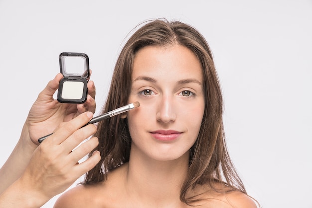 Gratis foto visagiste die make-up toepast op de vrouw