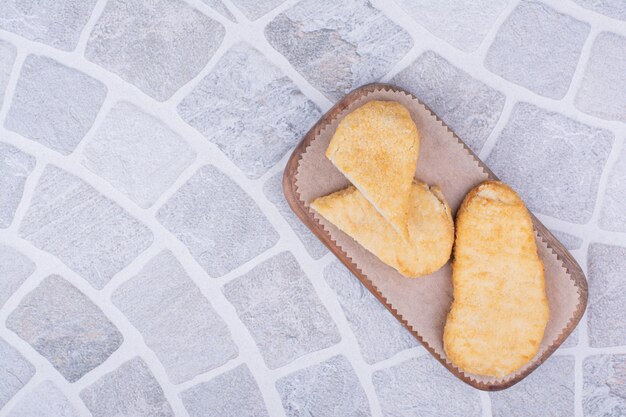 Visnuggets geïsoleerd op een houten bord.