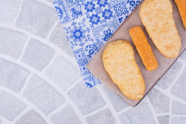 Visnuggets geserveerd op een houten bord.