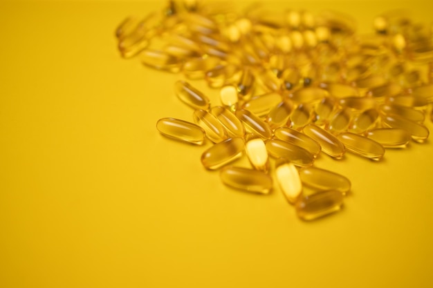 Visolie omega 3 gel capsules geïsoleerd op gele achtergrond. zorgconcept