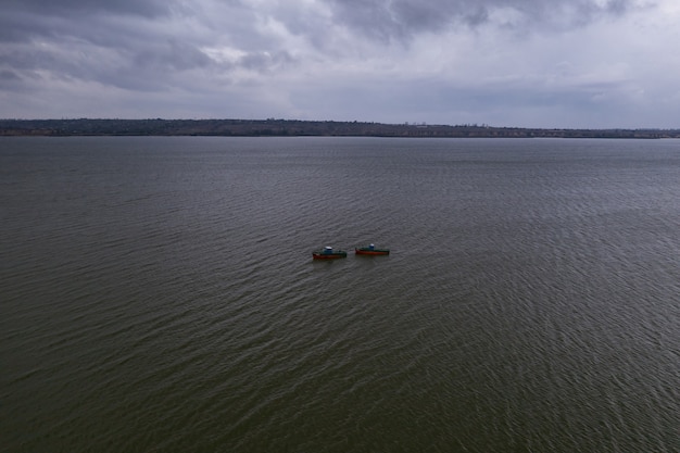 Vissersboten, drijvend in de kalme wateren en gaan vissen onder een hemel met wolken