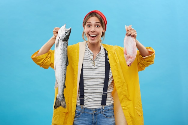 Gratis foto vissersvrouw die haar succesvolle vangst toont