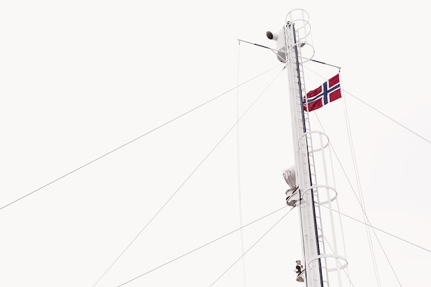 Vlag van Noorwegen op de wind onder de witte hemel