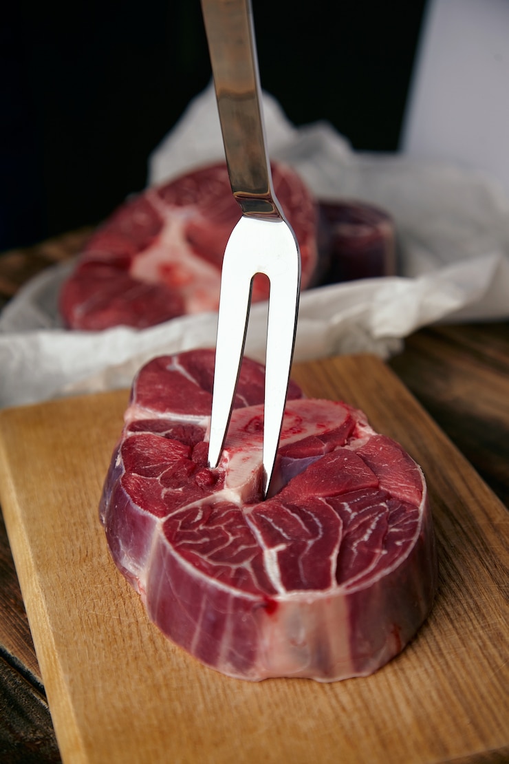 Gratis Foto vleesvork in angus steak. close-up op houten tafel, voor ongericht steaks.