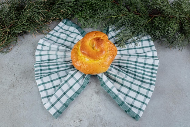 Vlindervormige handdoek onder een zoet broodje op een marmeren ondergrond