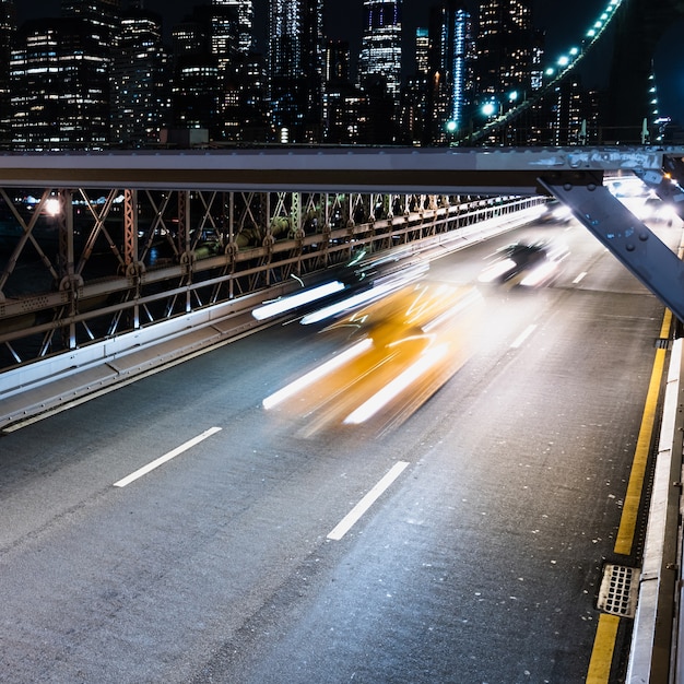 Voertuigen op brug met motion blur 's nachts