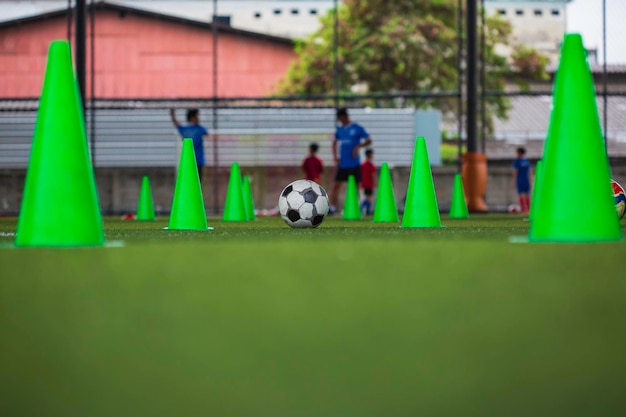 Voetbal bal tactiek kegel op grasveld met voor opleiding achtergrond kinderen trainen in voetbal
