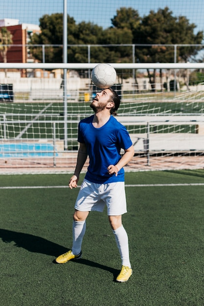 Gratis foto voetballer met bal op het hoofd